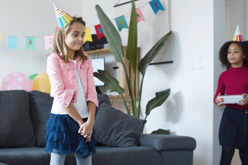 Girl in Birthday Cone Standing and Waiting for Gifts