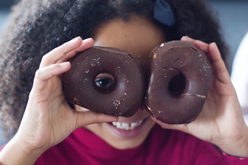 A Girl Holding Chocolate Donuts