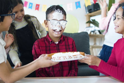 Children having fun at a birthday party with cake and laughter indoors.