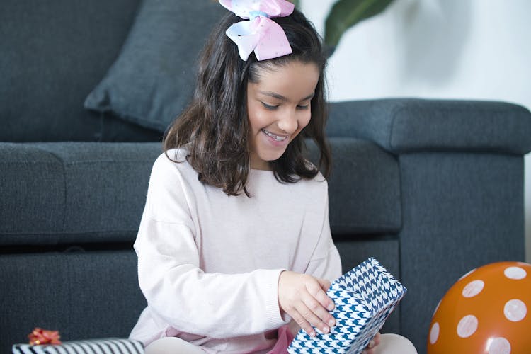 A Girl Unwrapping A Gift