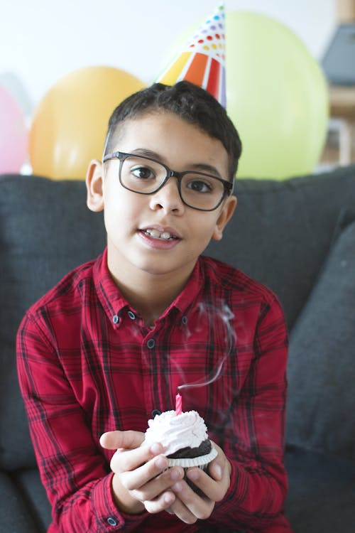 Free Boy in Plaid Shirt Holding a Cupcake with Candle Stock Photo