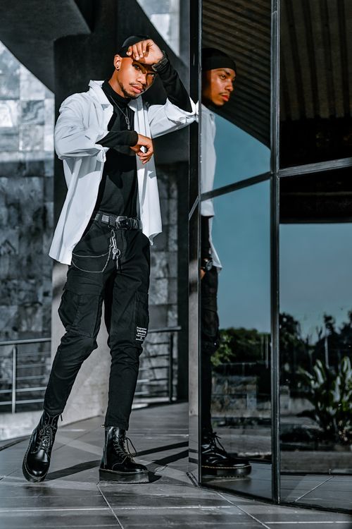 Free Stylish man posing outdoors with his reflection in a mirror, showcasing modern fashion. Stock Photo