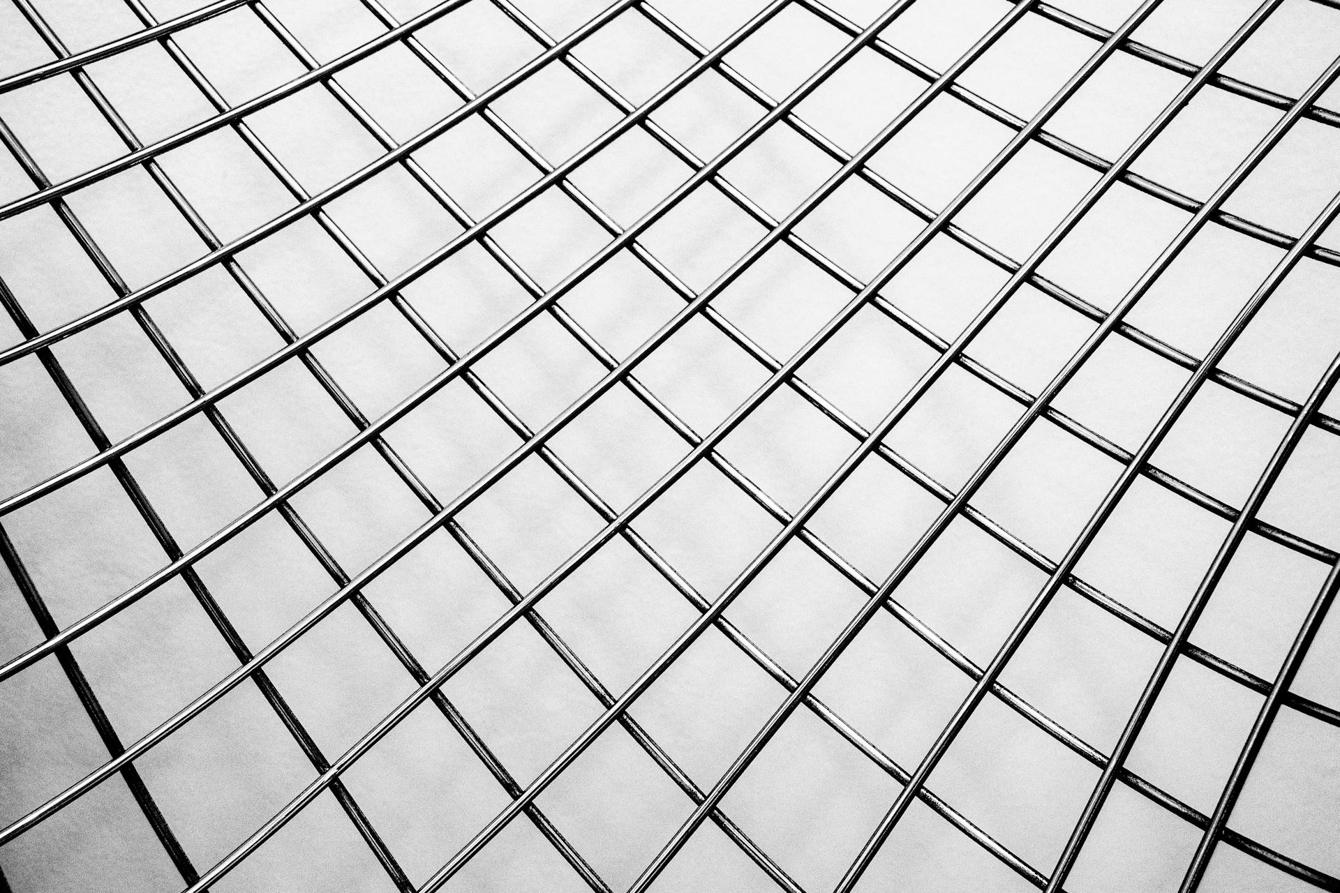 Close-up of a metal grid displaying a geometric pattern, creating an artistic effect.