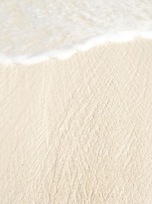 Free Peaceful white sand and gentle sea foam meet in Cancún, capturing serene coastal beauty. Stock Photo
