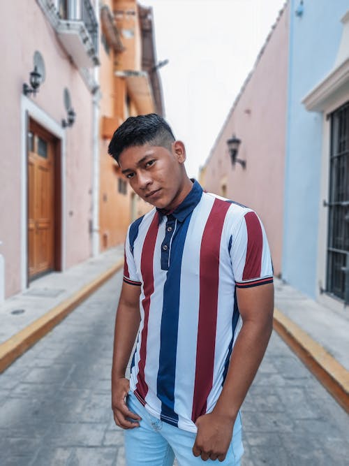 Man in White Red and Blue Striped Polo Shirt Standing on Sidewalk