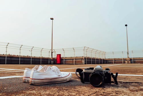 Black Camera Beside White Sneakers