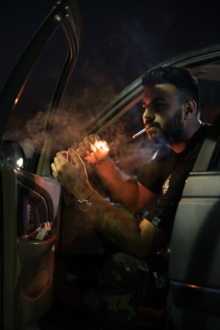 Man Smoking Cigarette In Car At Night