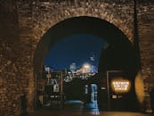Brick Gate and a Modern City Illuminated at Night