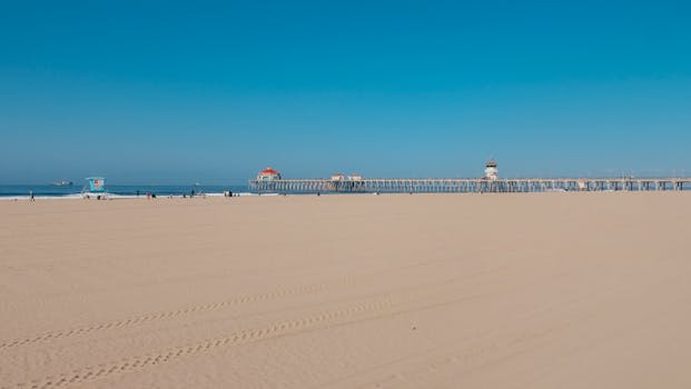 A sunny summer day at Huntington Beach with a clear sky and sandy shore.