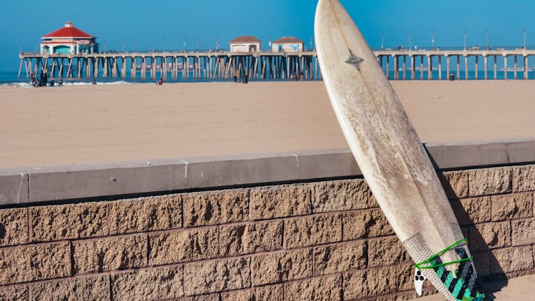A Surfboard On A Brick Fence