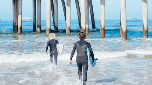 Free Surfers Wearing Wetsuits Stock Photo