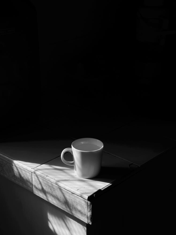 White Ceramic Cup On Edge Of Tiled Counter