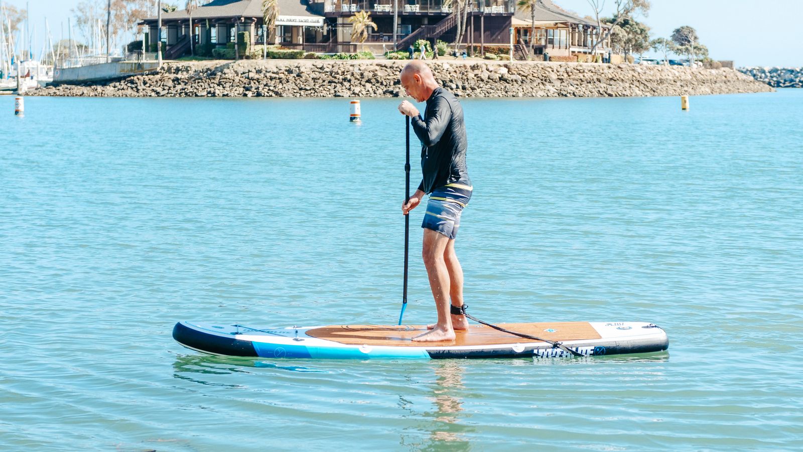 Paddleboarder traveling across calm open water