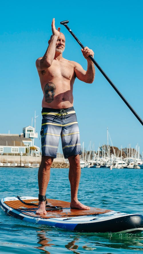 Free A Topless Paddleboarder in the Sea Stock Photo