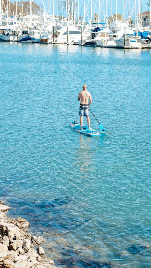 A Topless Paddleboarder in the Sea