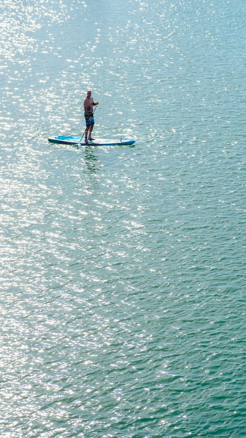 A Topless Paddleboarder in the Sea