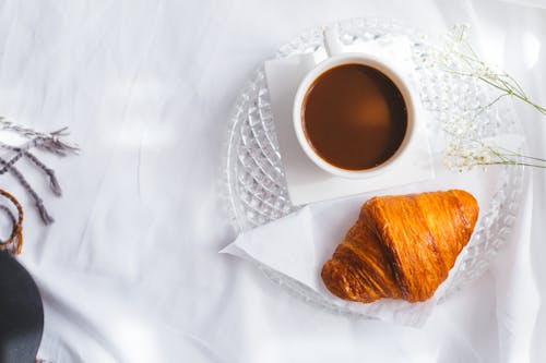 Free Overhead Shot of a Croissant Beside a Cup of Coffee Stock Photo