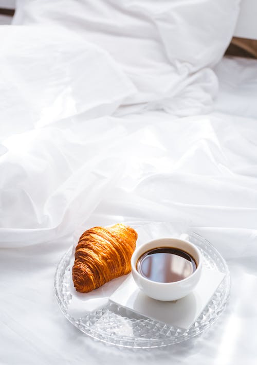 Free Photo of a Cup of Coffee Beside a Croissant Stock Photo