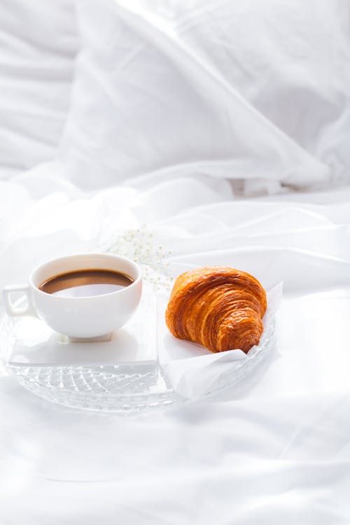 Free Photo of a Glass Plate with a Cup of Coffee and a Croissant Stock Photo