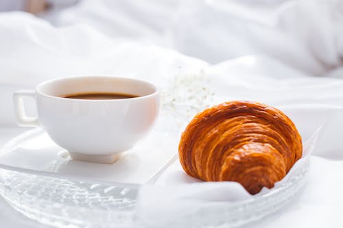 Free A Brown Croissant Beside a White Cup Stock Photo