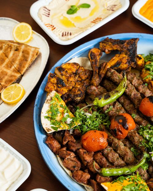 Free A vibrant kebab platter with grilled meat, vegetables, and traditional sides, perfect for a feast. Stock Photo
