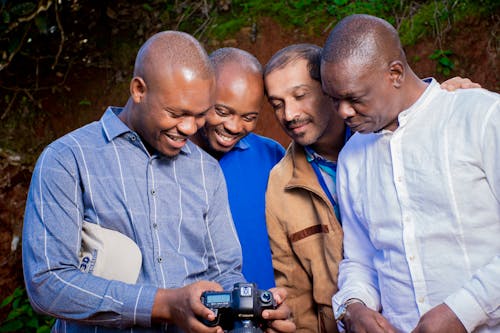Free Close-Up Shot of Men Smiling while Looking at a Camera Stock Photo
