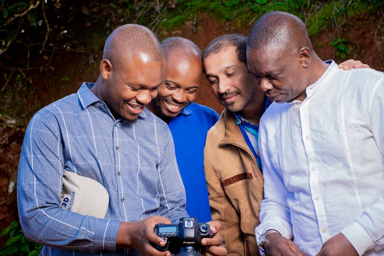 Close-Up Shot Of Men Smiling While Looking At A Camera