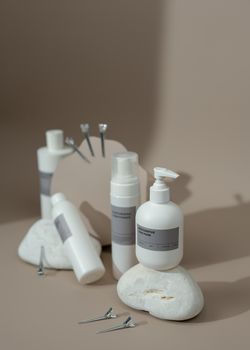 Minimalist display of cosmetic bottles with hair accessories on stones, ideal for beauty product promotion.