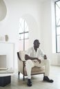 Man in White Button Up Shirt Sitting on White Armchair