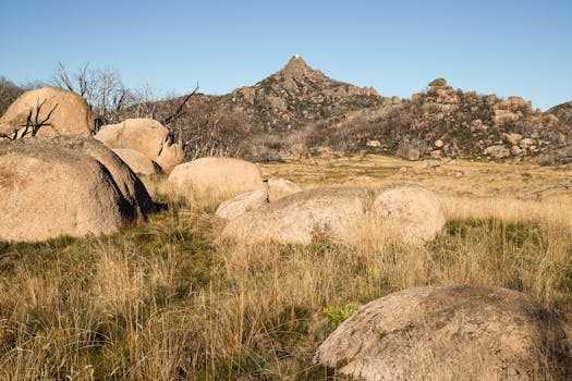 Explore the rugged and serene landscape of Mount Buffalo with its stunning boulders and clear blue sky.