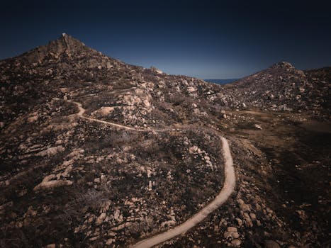 Dramatic aerial view of a winding path through rugged terrain at Mount Buffalo, Australia.