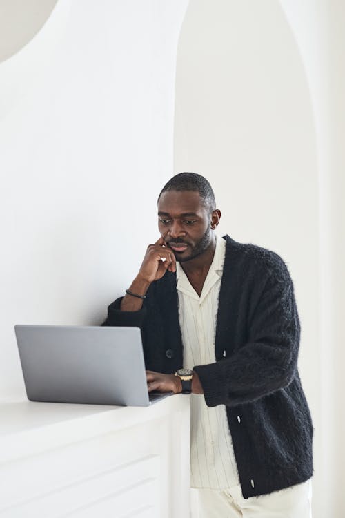 Man in Black Cardigan Using a Laptop