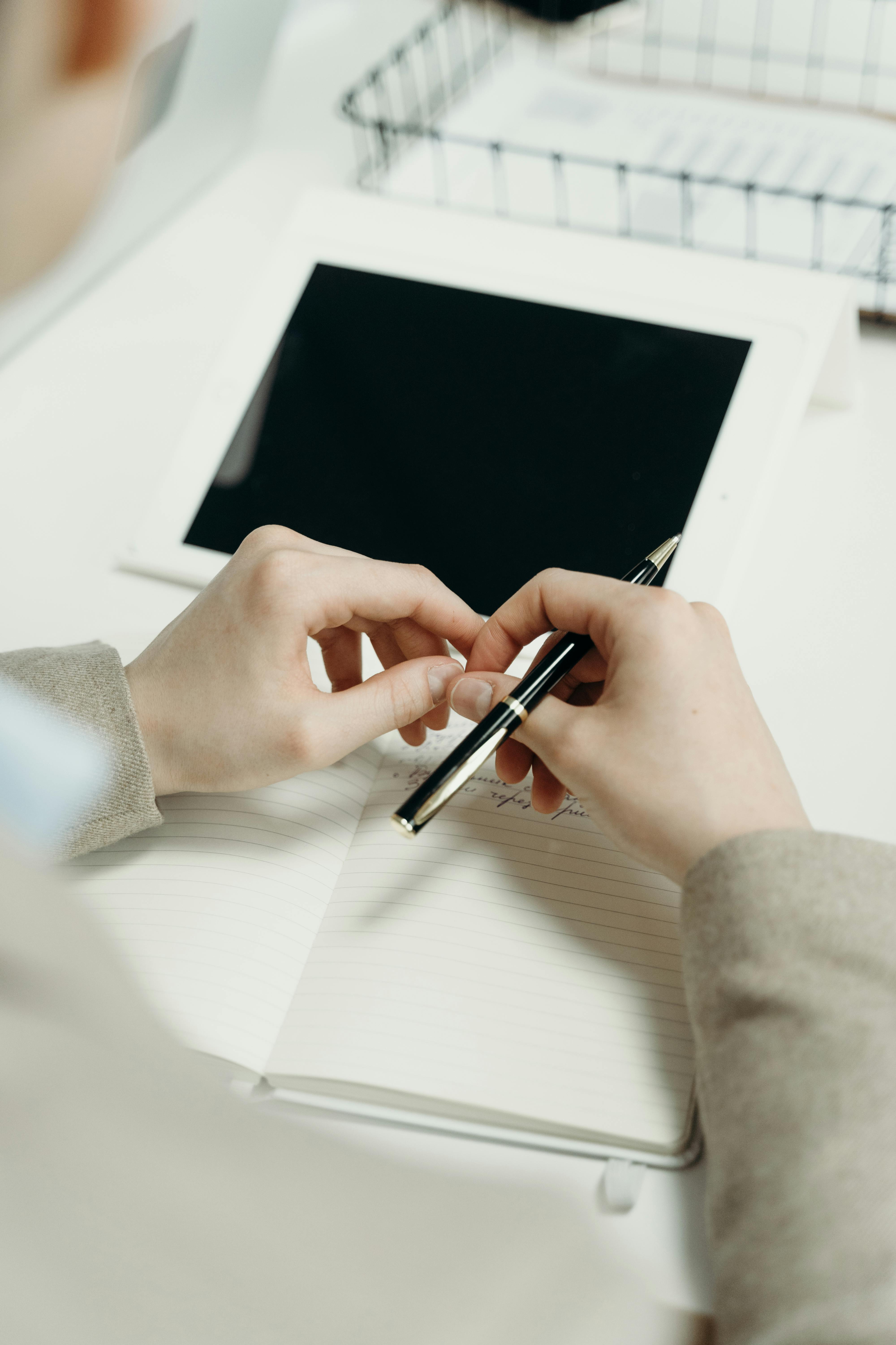 Person Holding a Pen · Free Stock Photo