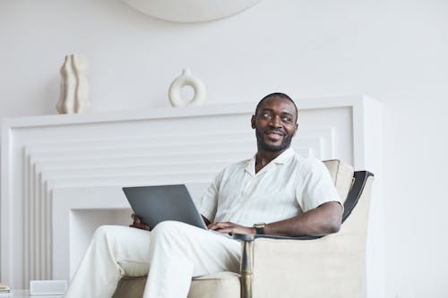 Free Man in White Button Up Shirt Sitting on White Armchair Stock Photo