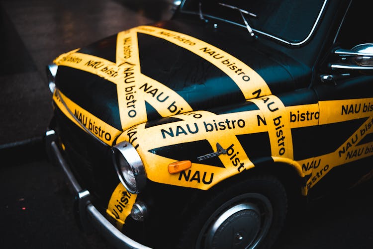 Old Fashioned Black Car Decorated With Yellow Adhesive Tape