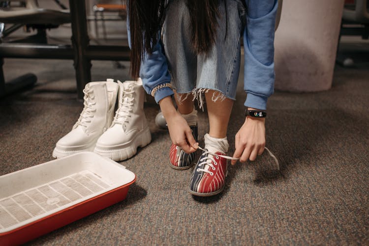 A Person Tying The Shoelaces Of Bowling Shoes