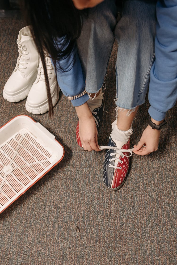 A Woman Tying Her Bowling Shoe