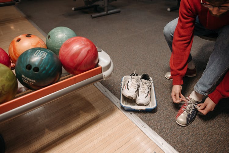 A Person Putting On Bowling Shoes