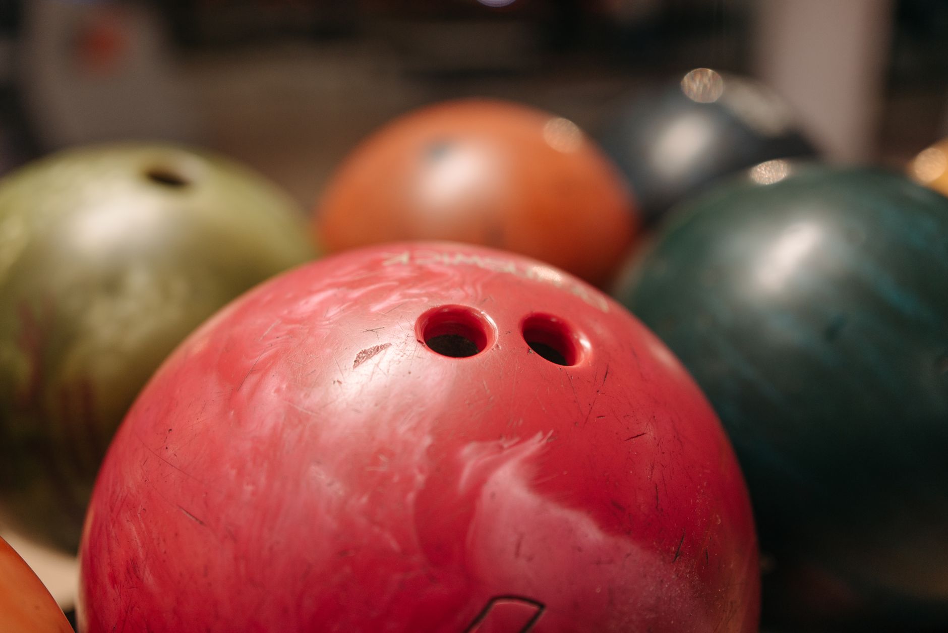 A close-up view of colorful bowling balls with visible holes, showcasing vibrant colors and depth of field.