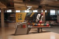 A man selects a bowling ball in a stylish and contemporary bowling center.