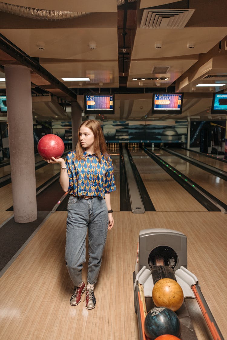 A Woman Gripping A Bowling Ball