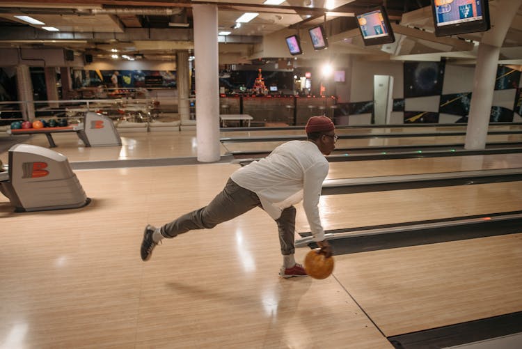 A Man Releasing A Bowling Ball