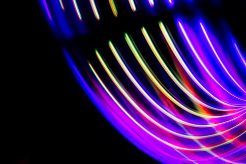 Free A dynamic long exposure capturing vibrant neon light streaks on a dark backdrop. Stock Photo