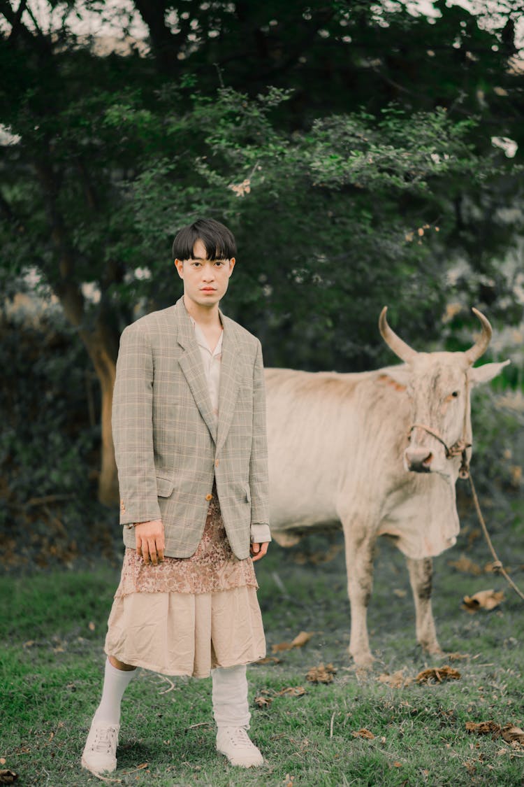 A Man With An Eccentric Clothing And A Cow