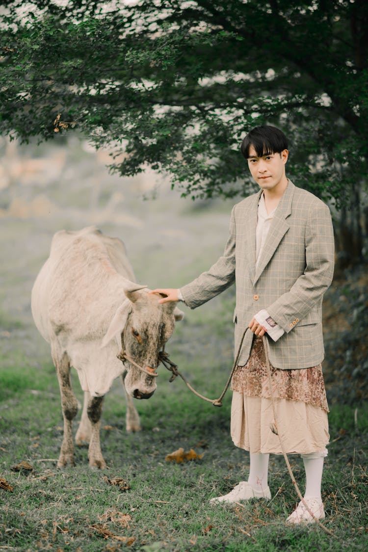 A Man In A Blazer Petting A Cow