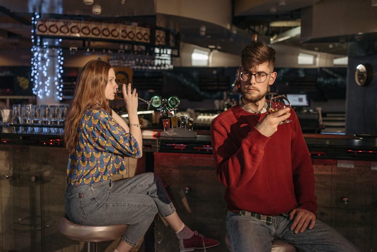 Friends Drinking Alcoholic Beverages At The Bar Counter