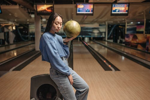 A Woman in a Crop Top Holding a Bowling Ball