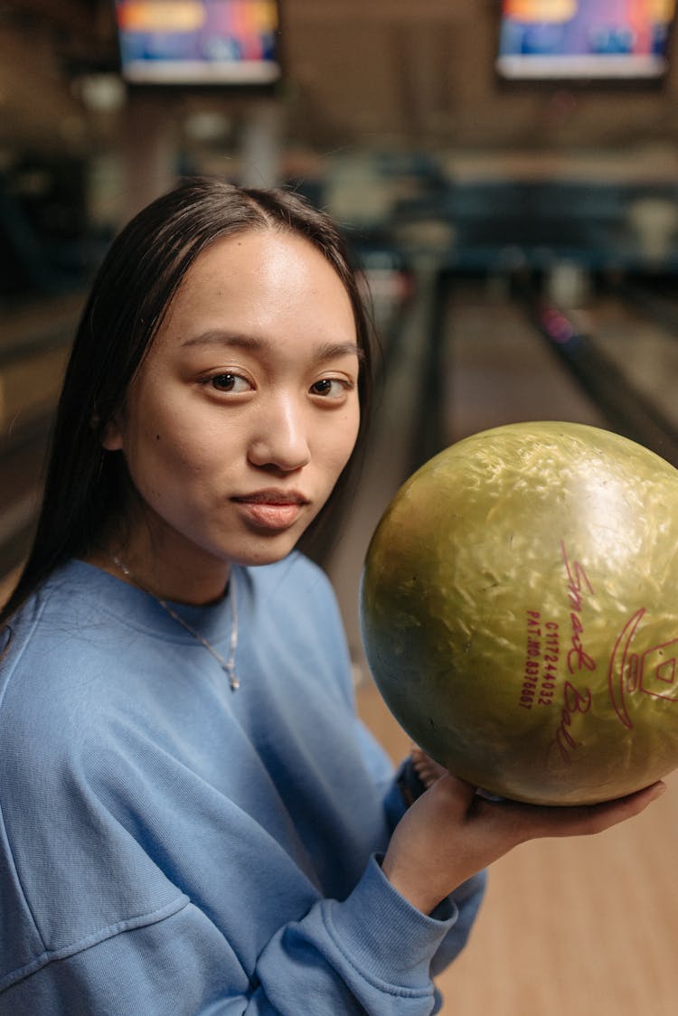 A Woman Holding A Bowling Ball