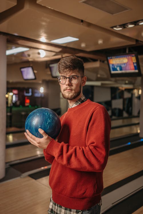 Man in Red Sweater Holding Blue Bowling Ball