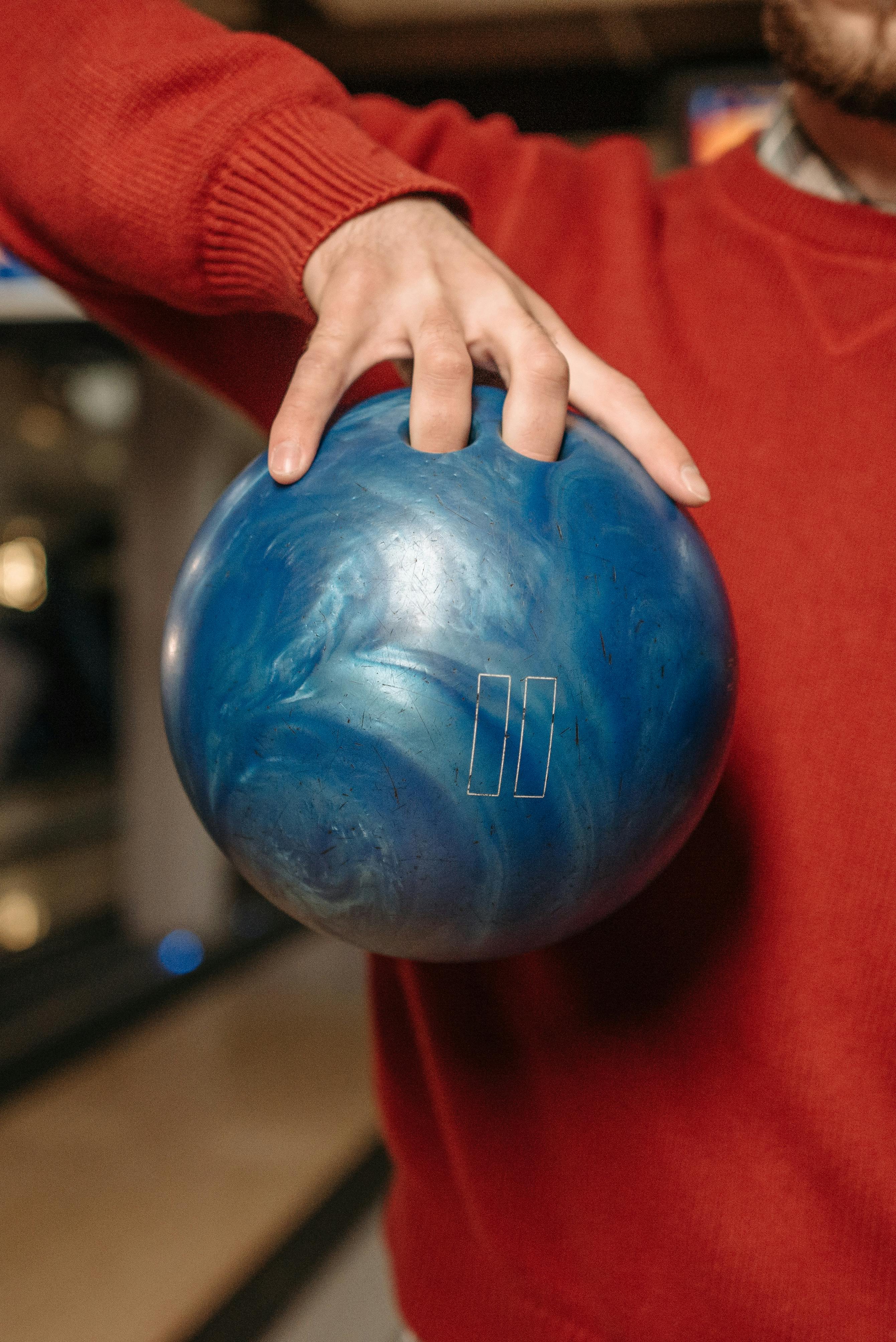 person in red sweater holding blue round ball